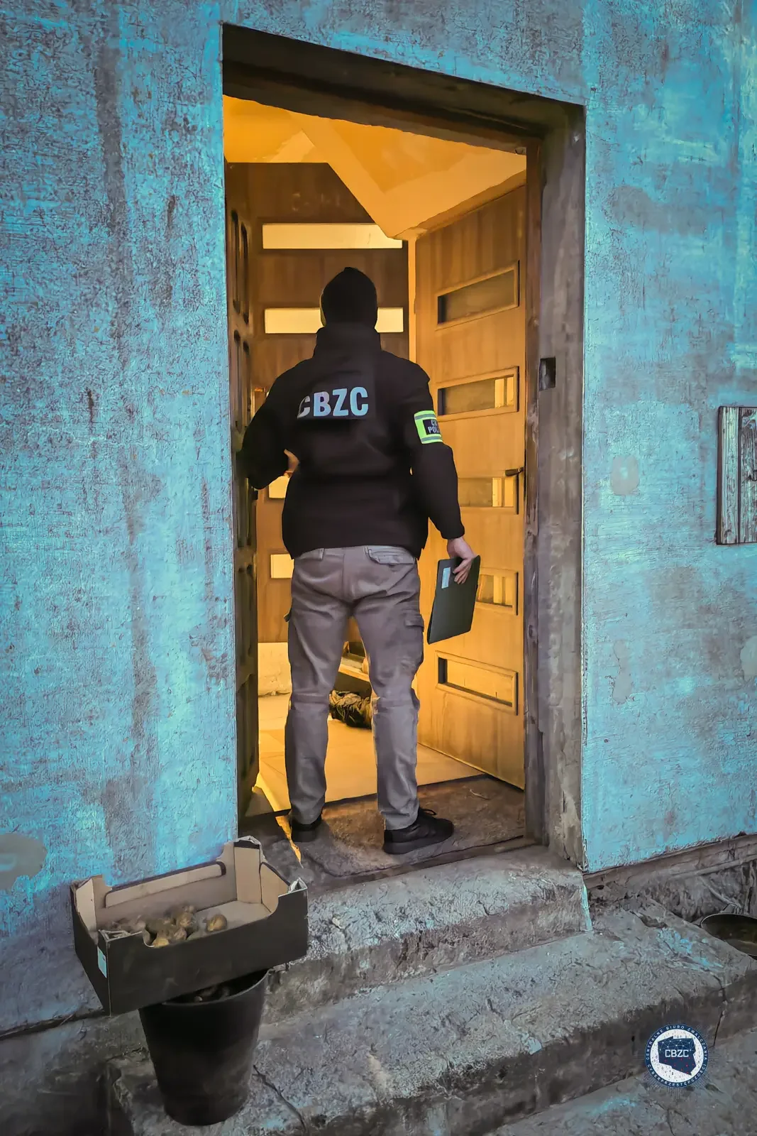 Сотрудник польского CBZC проводит обыск по адресу подозреваемого